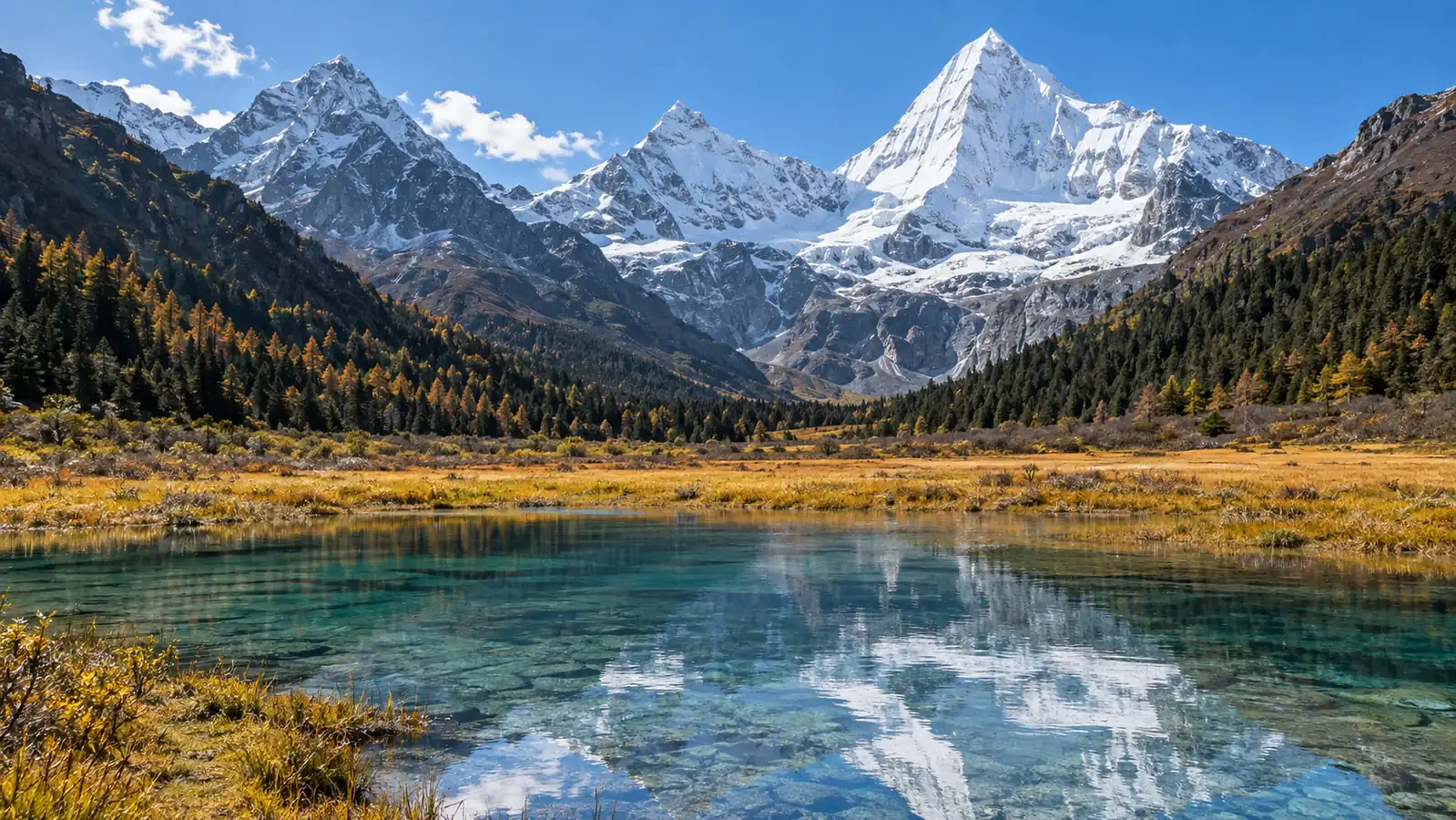 Daocheng Yading snow peaks above an alpine lake and meadow Daocheng Yading snow peaks above an alpine lake and meadow