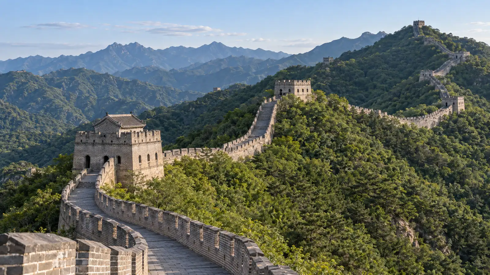 Restored Mutianyu Great Wall watchtowers winding across wooded mountain ridges