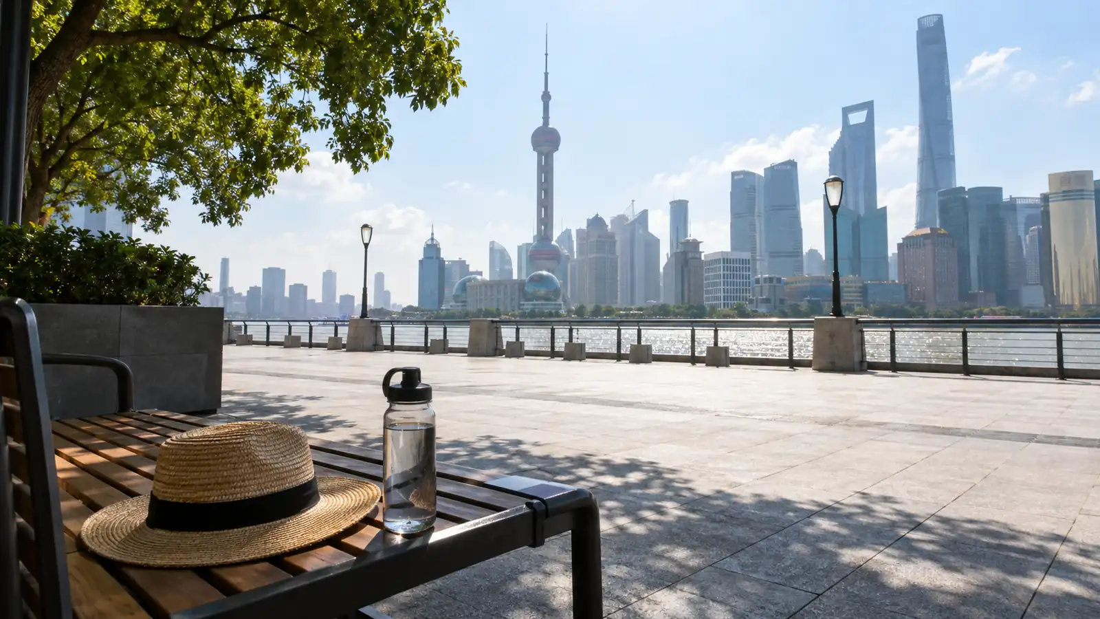 Sun hat and water bottle in shade beside the hot Bund promenade Sun hat and water bottle in shade beside the hot Bund promenade