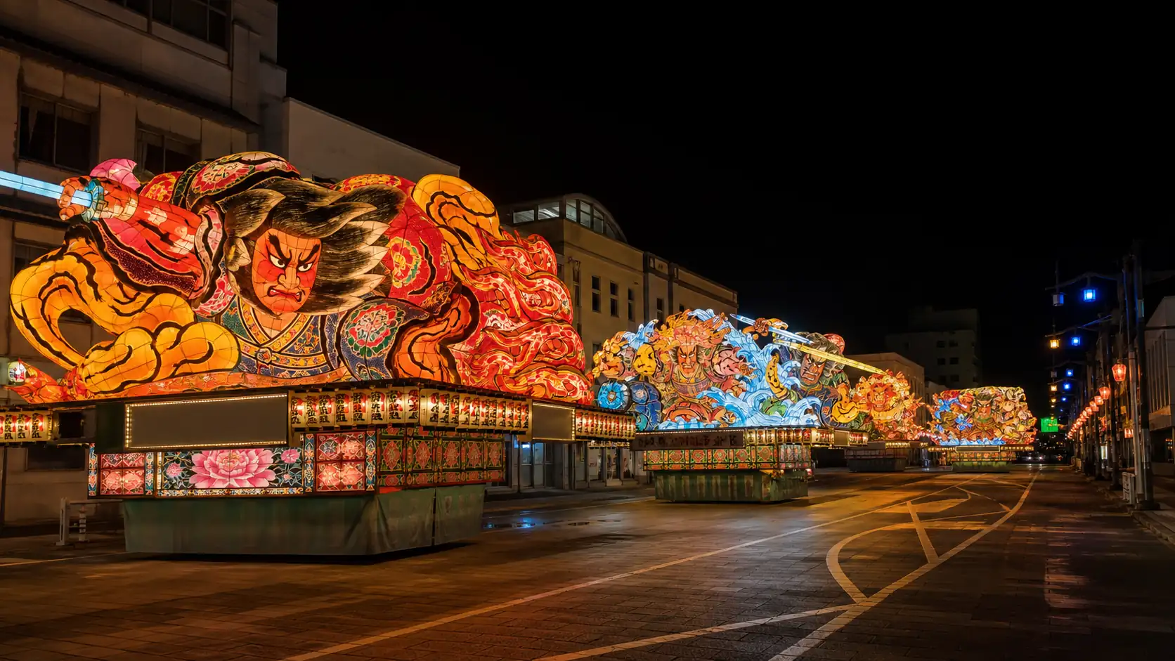 Illuminated Nebuta style festival floats on an empty Aomori street at night Illuminated Nebuta style festival floats on an empty Aomori street at night