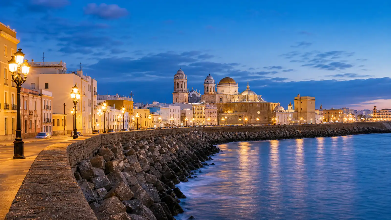 Cadiz waterfront promenade at blue hour with old town lights Cadiz waterfront promenade at blue hour with old town lights